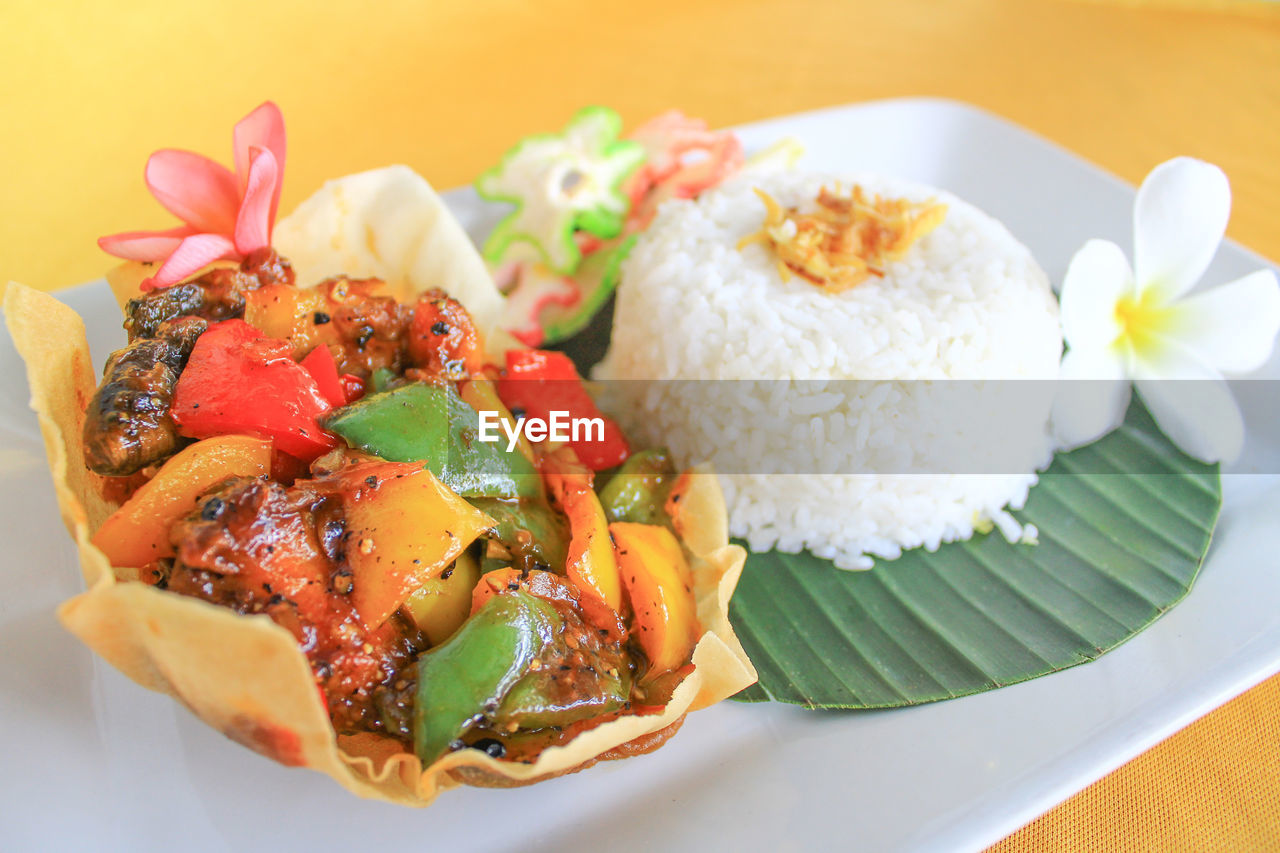 Chicken black pepper with rice and banana leaf as the base