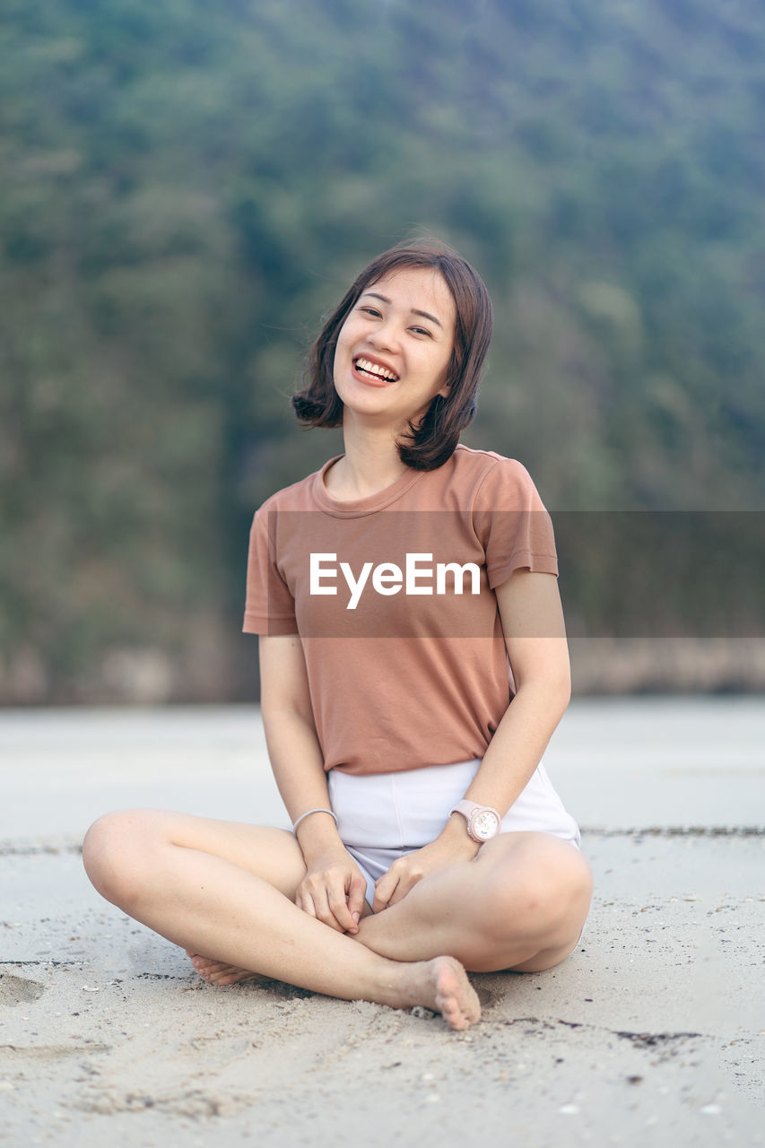 Portrait of smiling young woman sitting outdoors