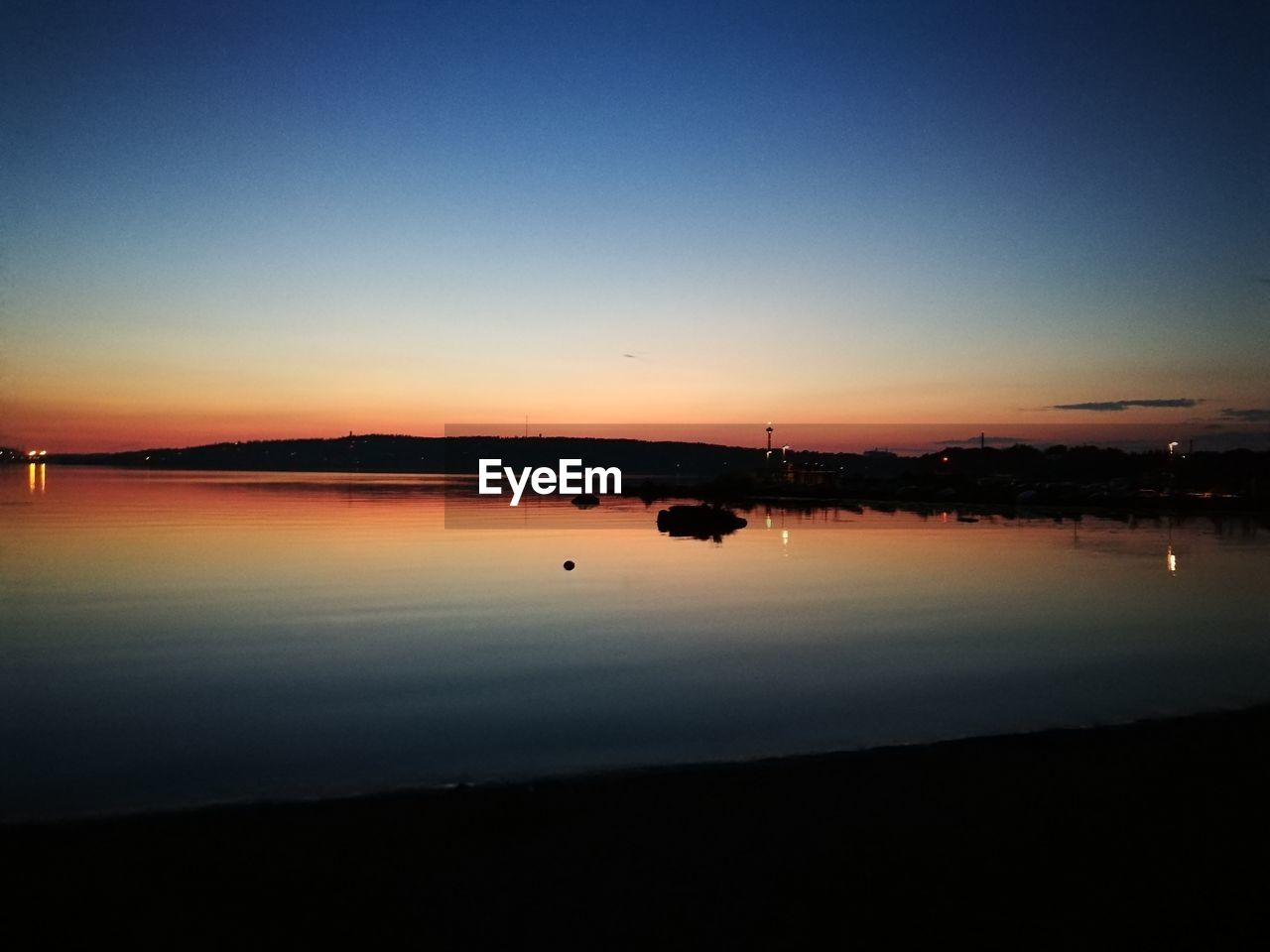 Scenic shot of calm lake at sunset