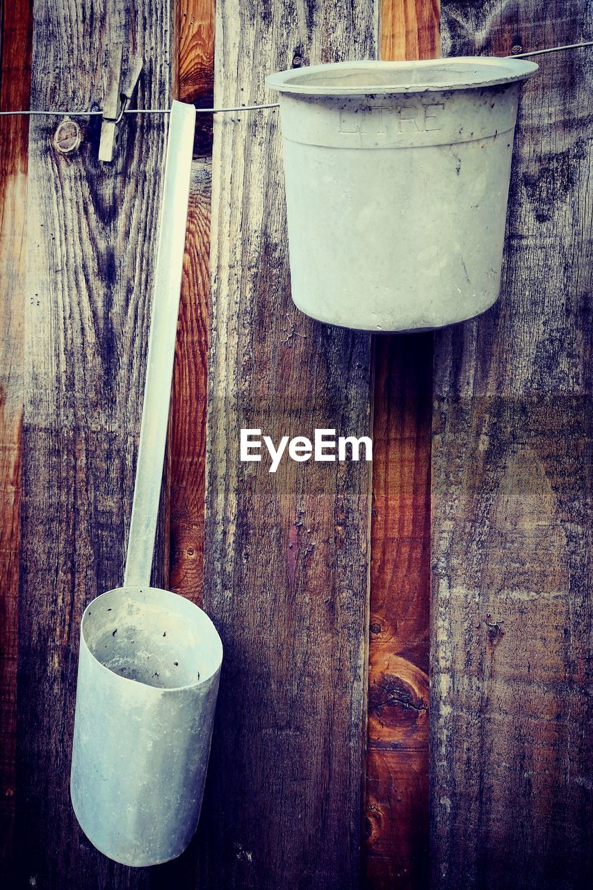 Close-up of measuring cup and container against wall