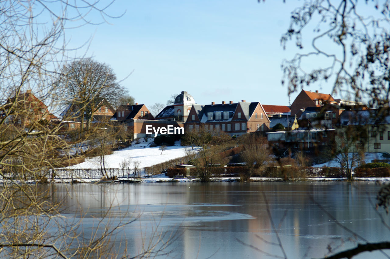 HOUSES BY RIVER AGAINST BUILDINGS