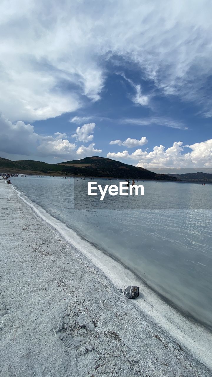 SCENIC VIEW OF BEACH BY MOUNTAINS AGAINST SKY