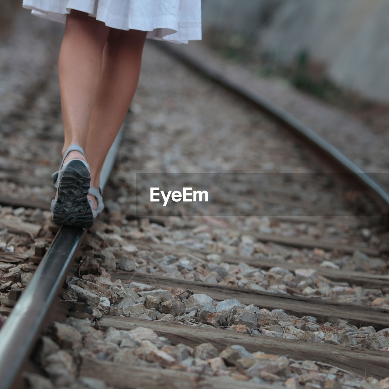 LOW SECTION OF WOMAN STANDING BY RAILROAD TRACK