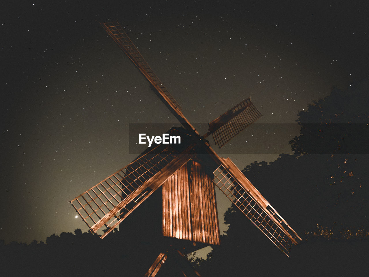 Low angle view of traditional windmill against sky at night