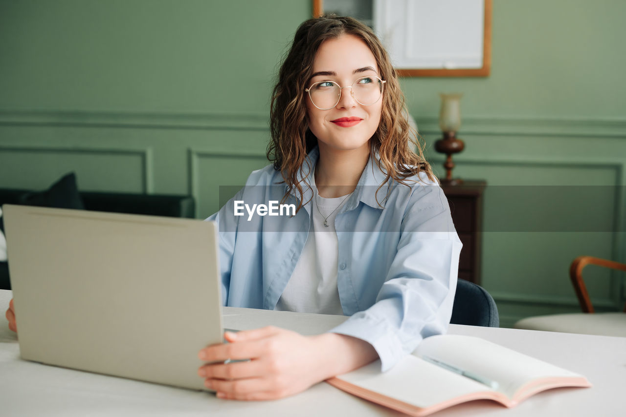 portrait of young woman using laptop on table