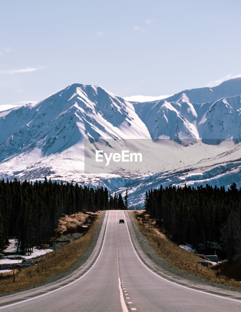 Road amidst snowcapped mountains against sky