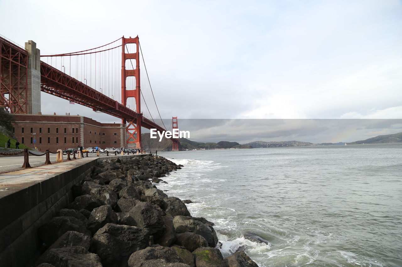 Golden gate bridge over bay of water against sky