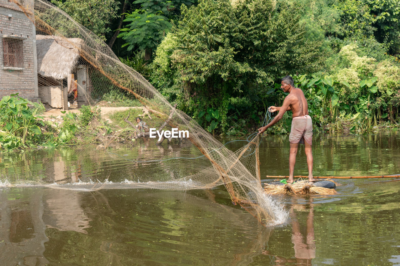 MAN STANDING IN LAKE