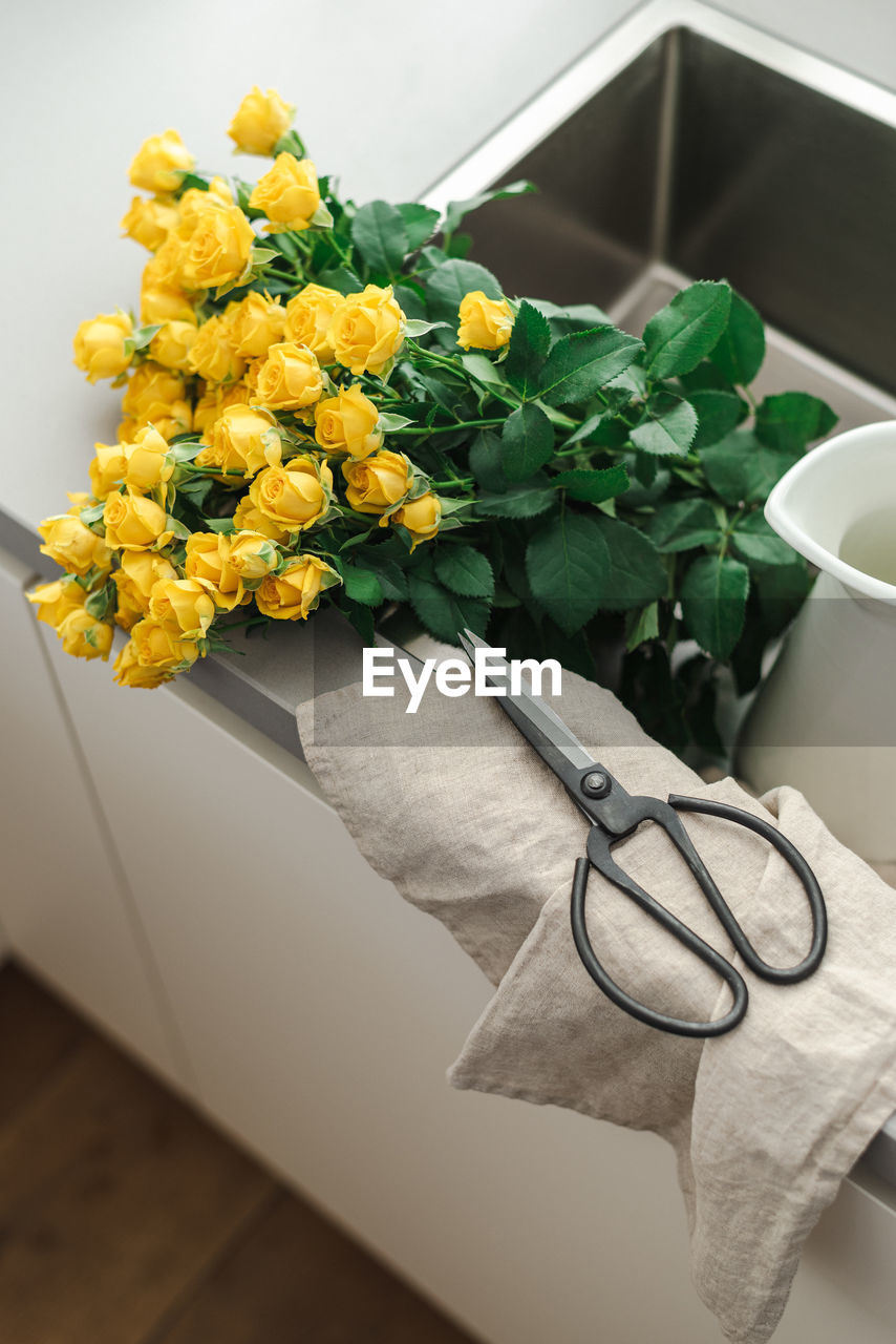 A bouquet of yellow garden roses in the kitchen sink.