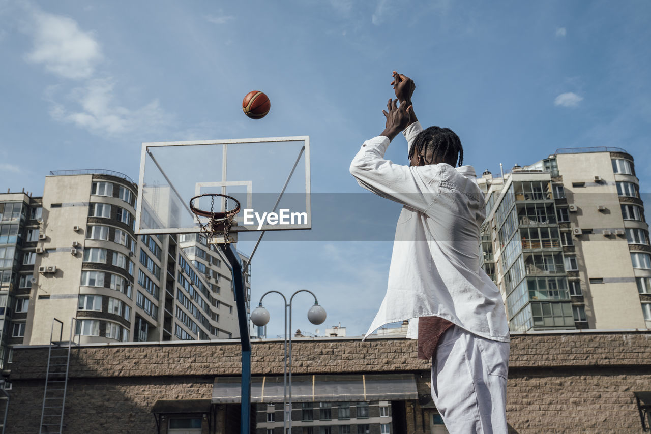 Young man throwing basketball in hoop