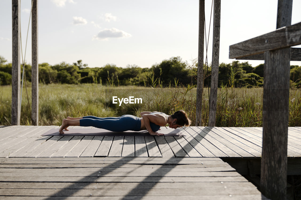 Woman in sports clothing doing yoga at gazebo