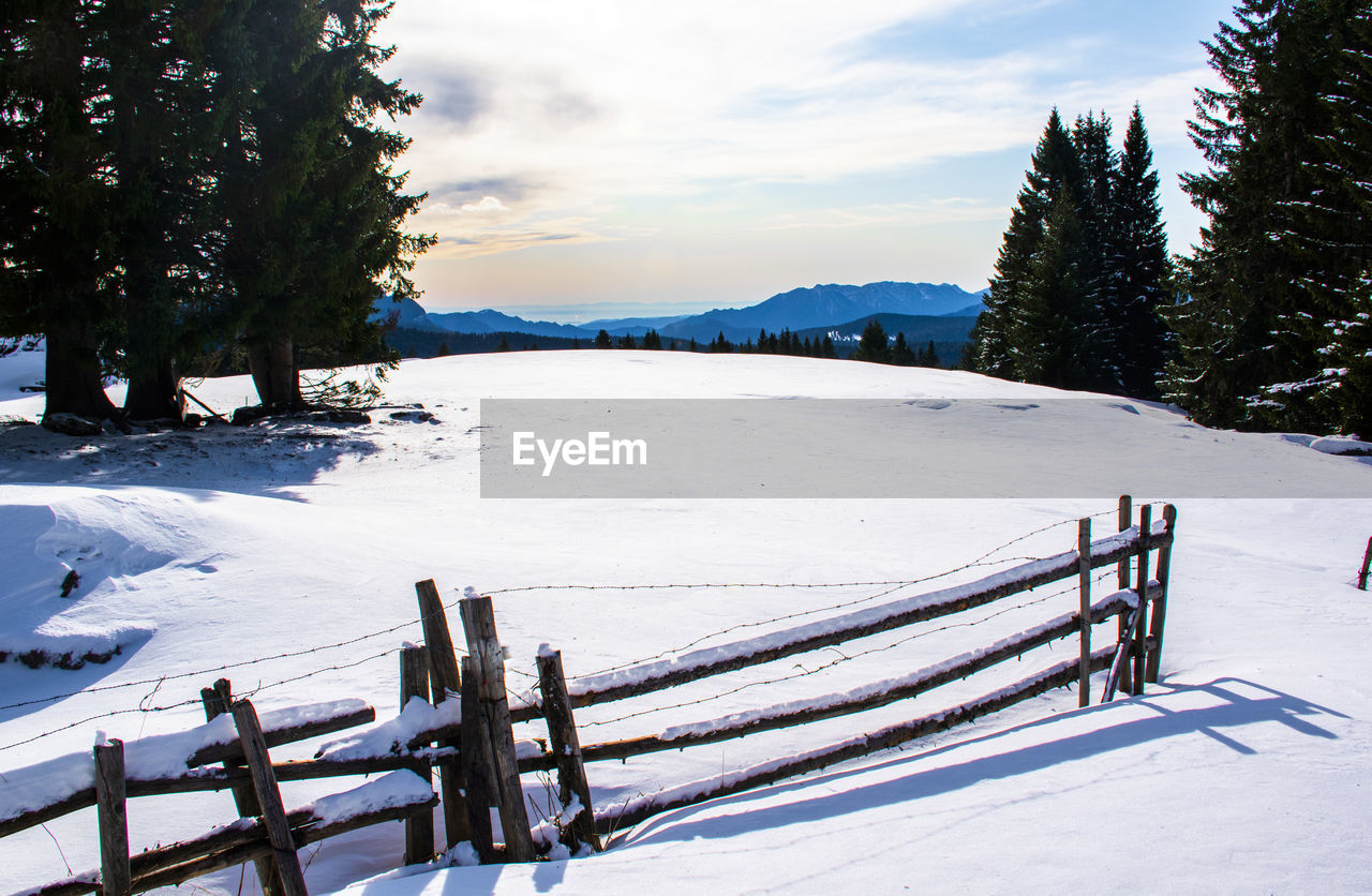 Scenic view of snow covered field against sky