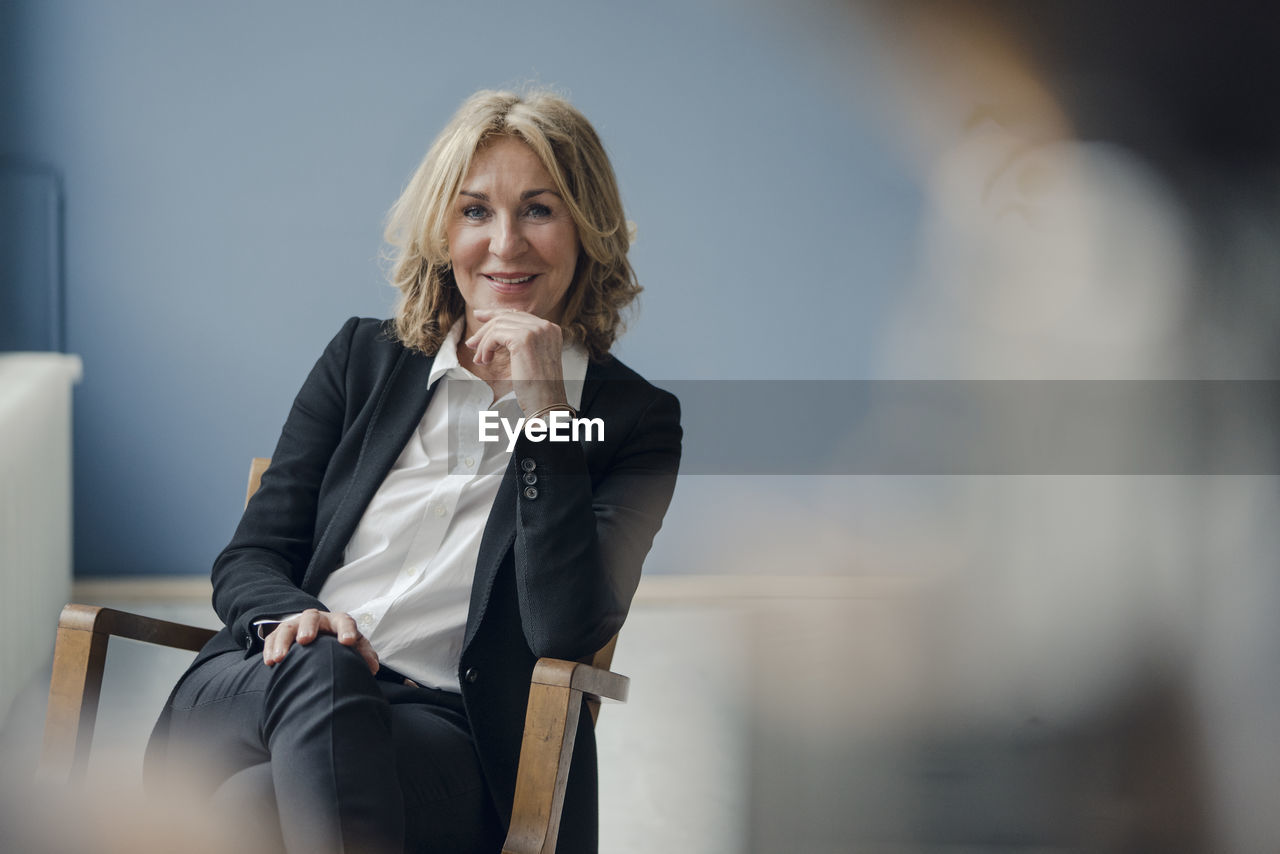 Portrait of smiling senior businesswoman sitting in chair