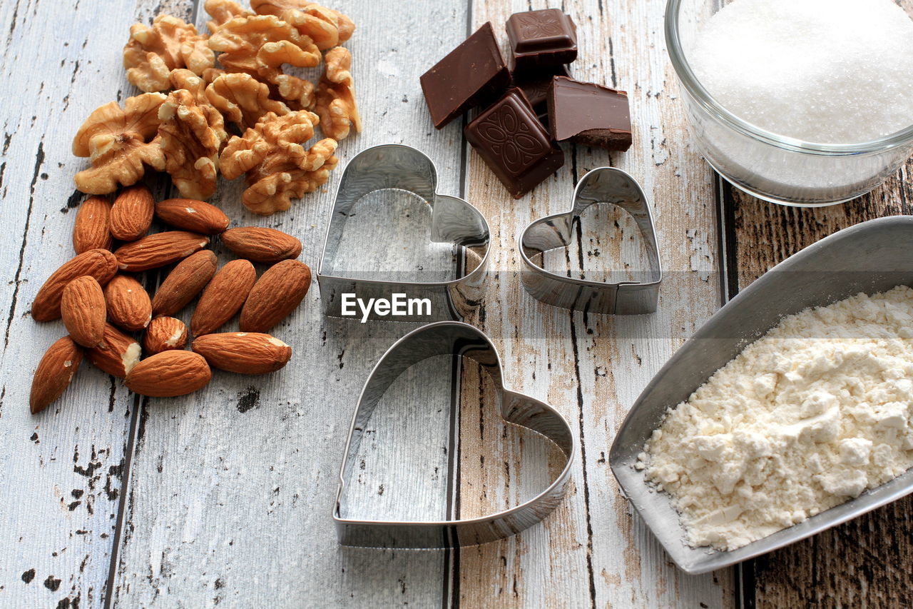 High angle view of almonds with chocolates and pastry cutters on table