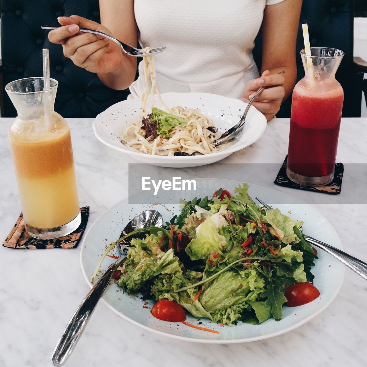 Midsection of woman eating noodles at restaurant