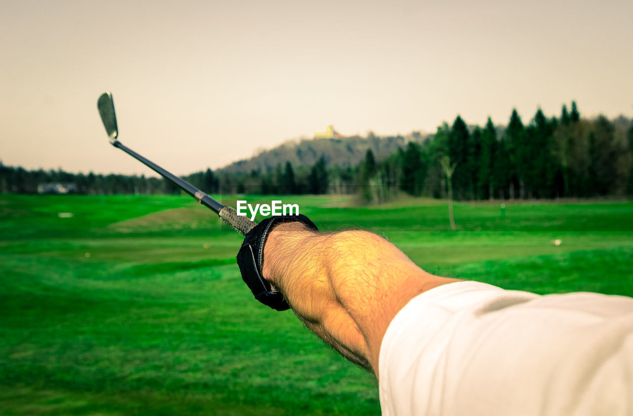 Cropped hand of man holding golf club