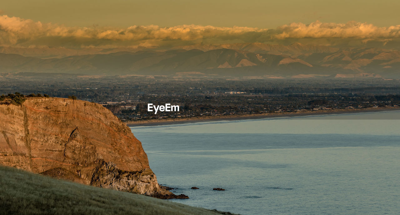 Scenic view of sea and mountains against sky