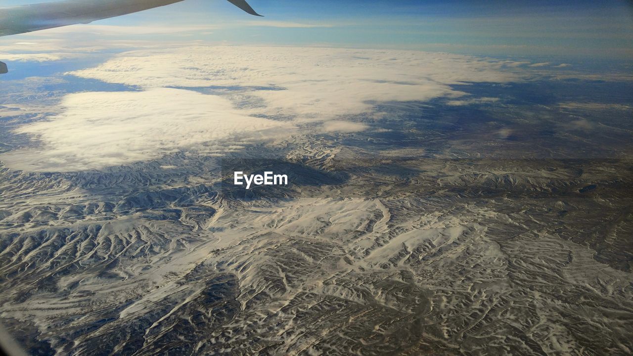 AERIAL VIEW OF SNOWCAPPED LANDSCAPE AGAINST SKY