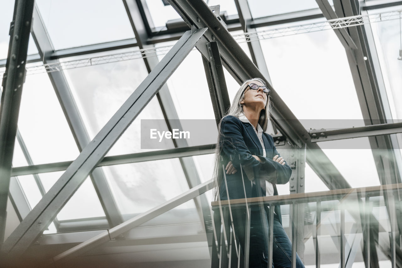 Woman with long grey hair standing in a loft