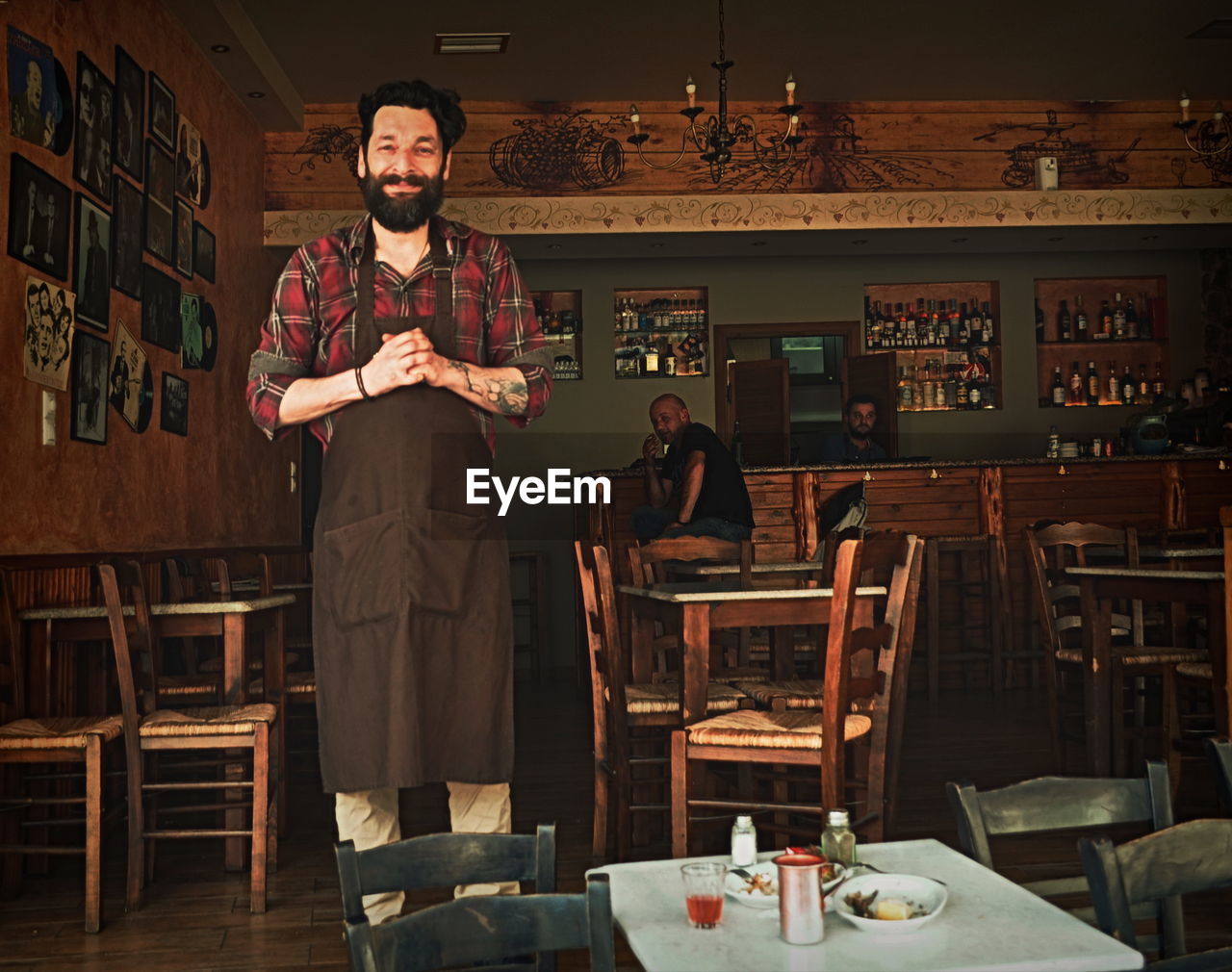 Portrait of young male barista standing in cafe