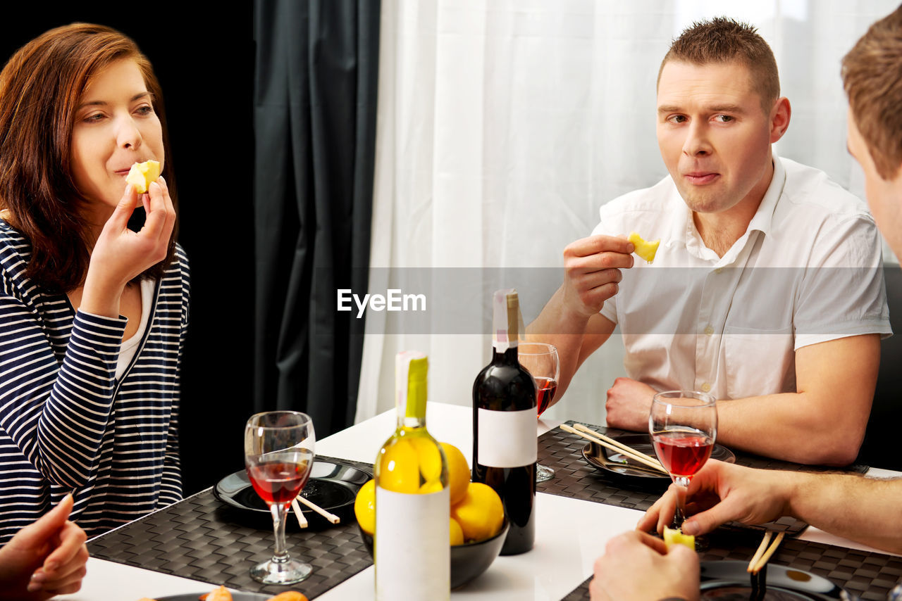 Couple having food and drink on dining table at home