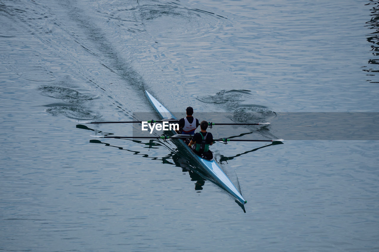 water, nautical vessel, rowing, transportation, sports, nature, oar, boating, men, high angle view, mode of transportation, cooperation, teamwork, day, lake, adult, sculling, motion, group of people, sport rowing, competition, outdoors, water sports, togetherness, lifestyles, scull, athlete, recreation, adventure, rowboat, leisure activity, waterfront