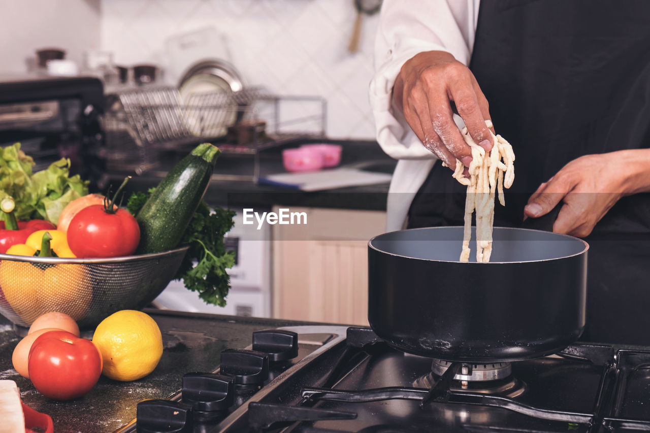 Midsection of male chef preparing food in kitchen