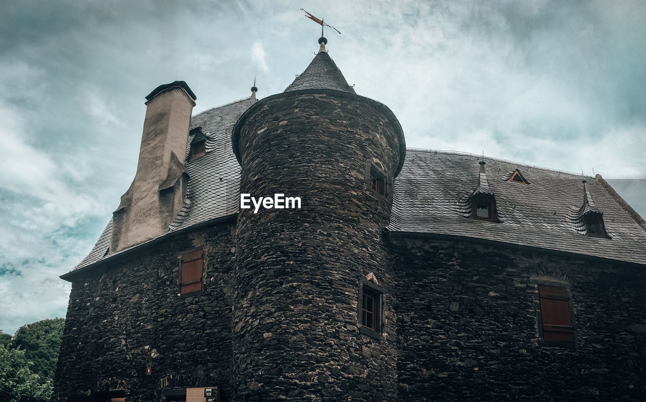 Low angle view of old building against cloudy sky