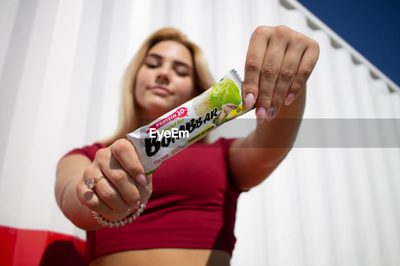 YOUNG WOMAN SMILING WHILE HOLDING HANDS AT HOME