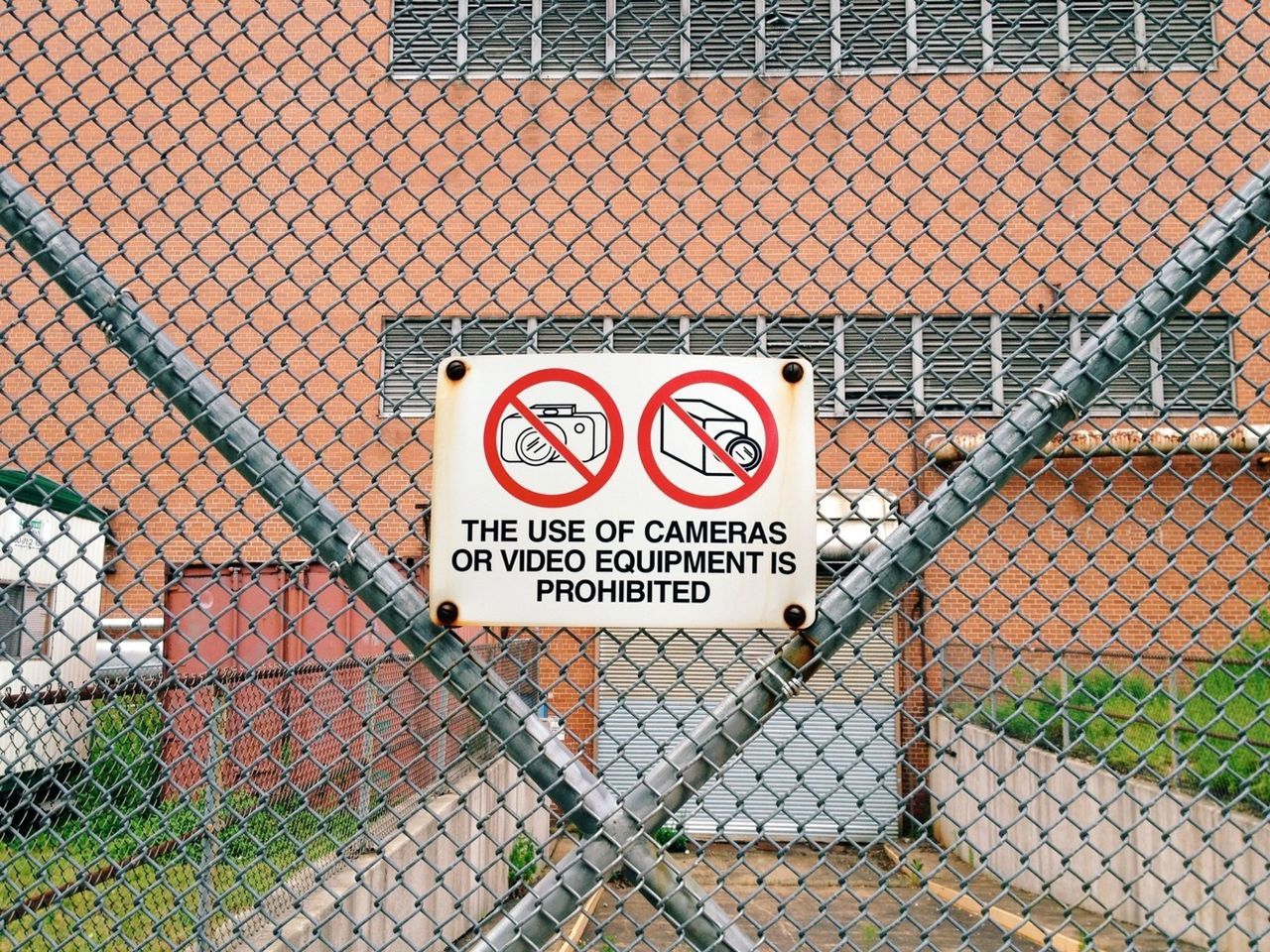 Close-up prohibition sign on wire mesh fence