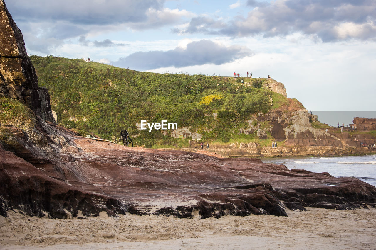 Scenic view of beach against cloudy sky