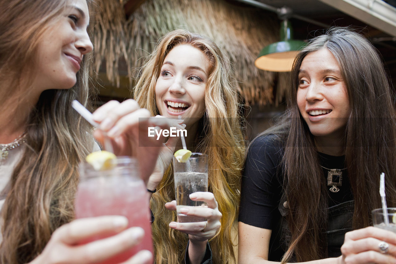 Happy young friends enjoying drinks at a bar