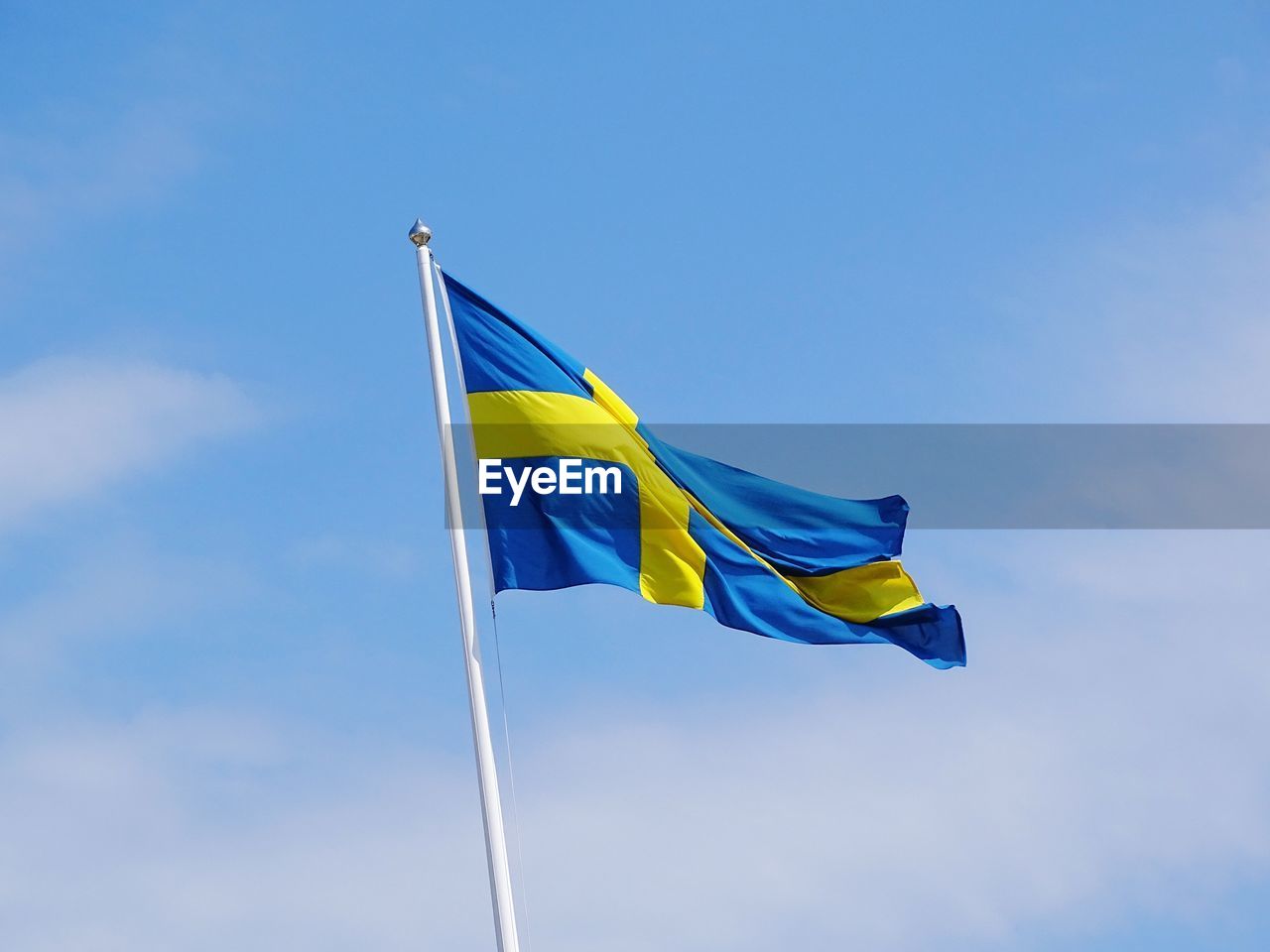 Low angle view of flag against blue sky