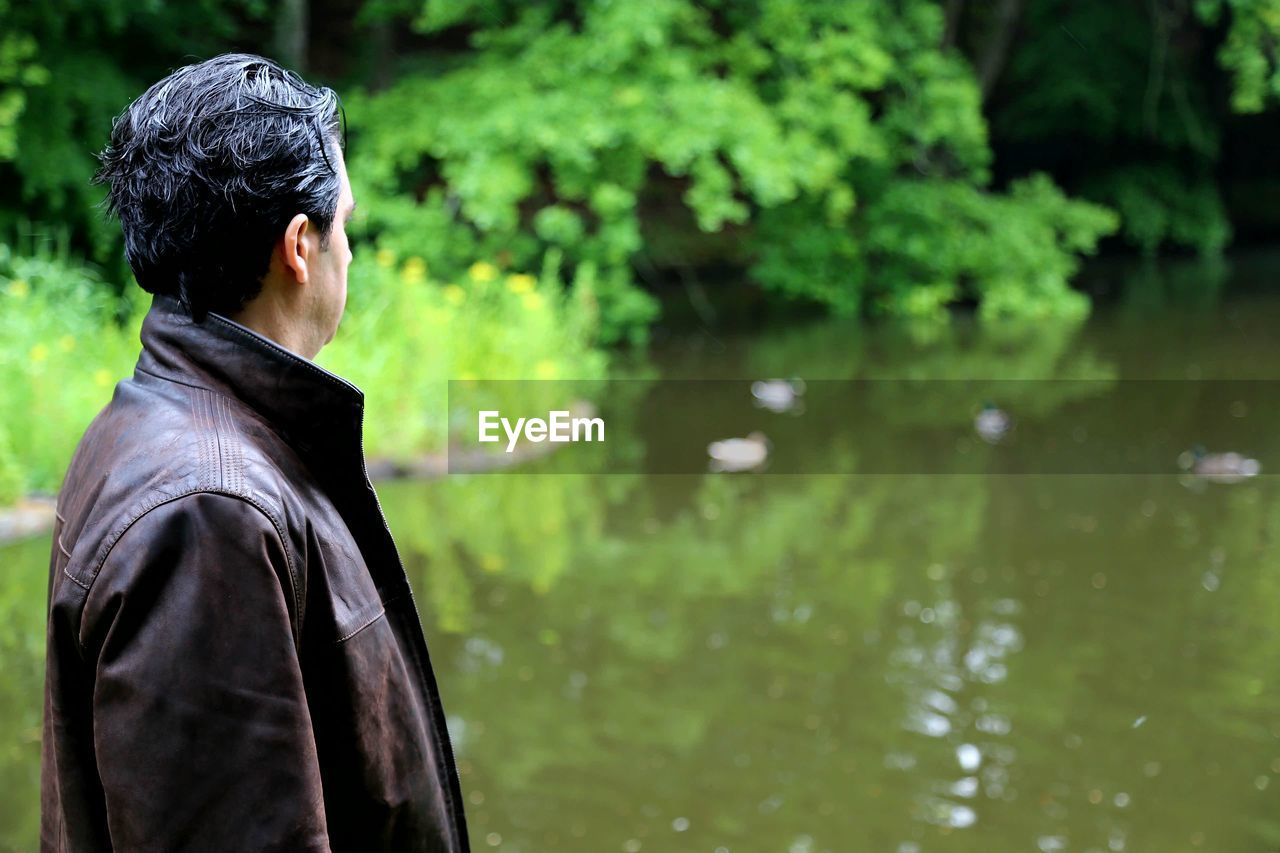 Side view of man standing by lake