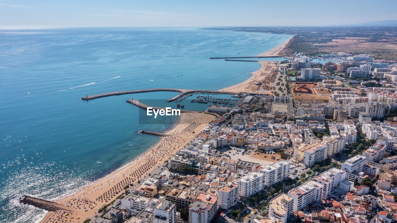 HIGH ANGLE VIEW OF BUILDINGS AGAINST SEA