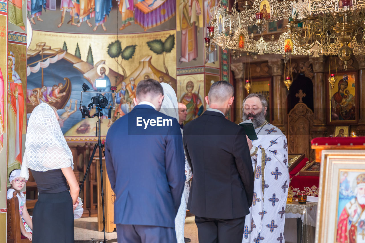 GROUP OF PEOPLE STANDING AT TEMPLE