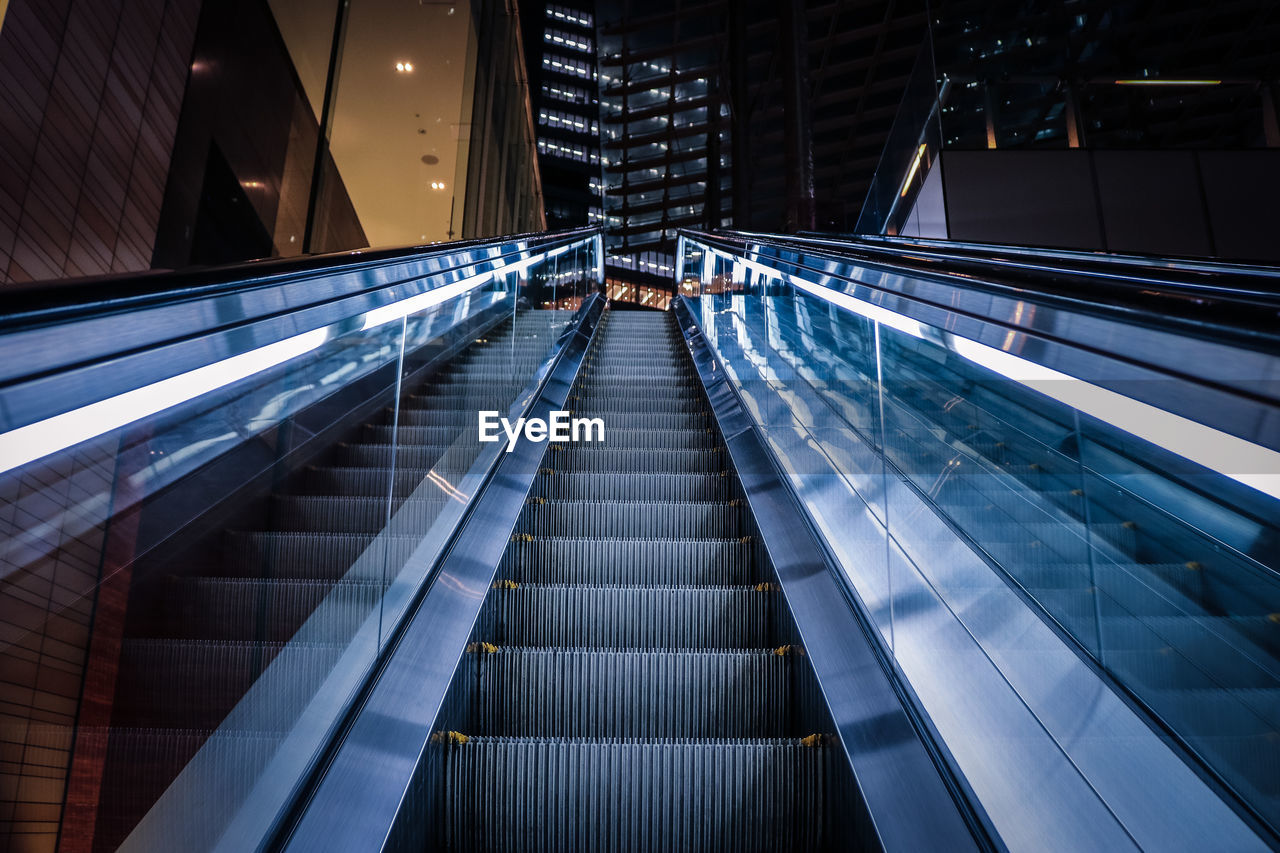 Low angle view of escalator in illuminated building