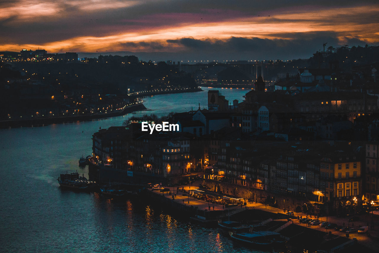 High angle view of city lit up at sunset