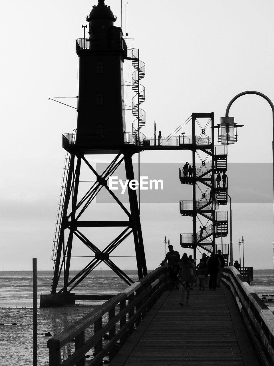 PEOPLE ON PIER AT SEA AGAINST CLEAR SKY