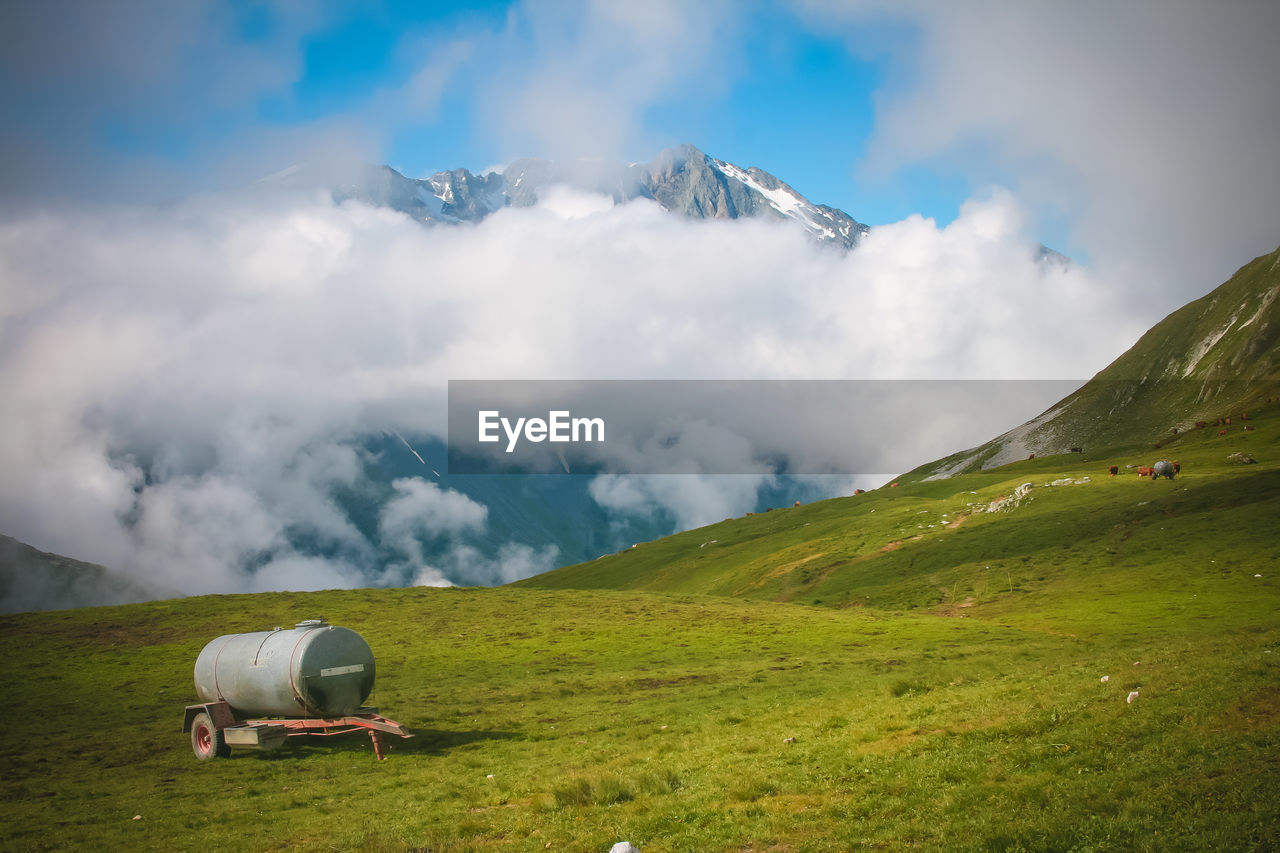 Scenic view of field and moutain range in alps against sky