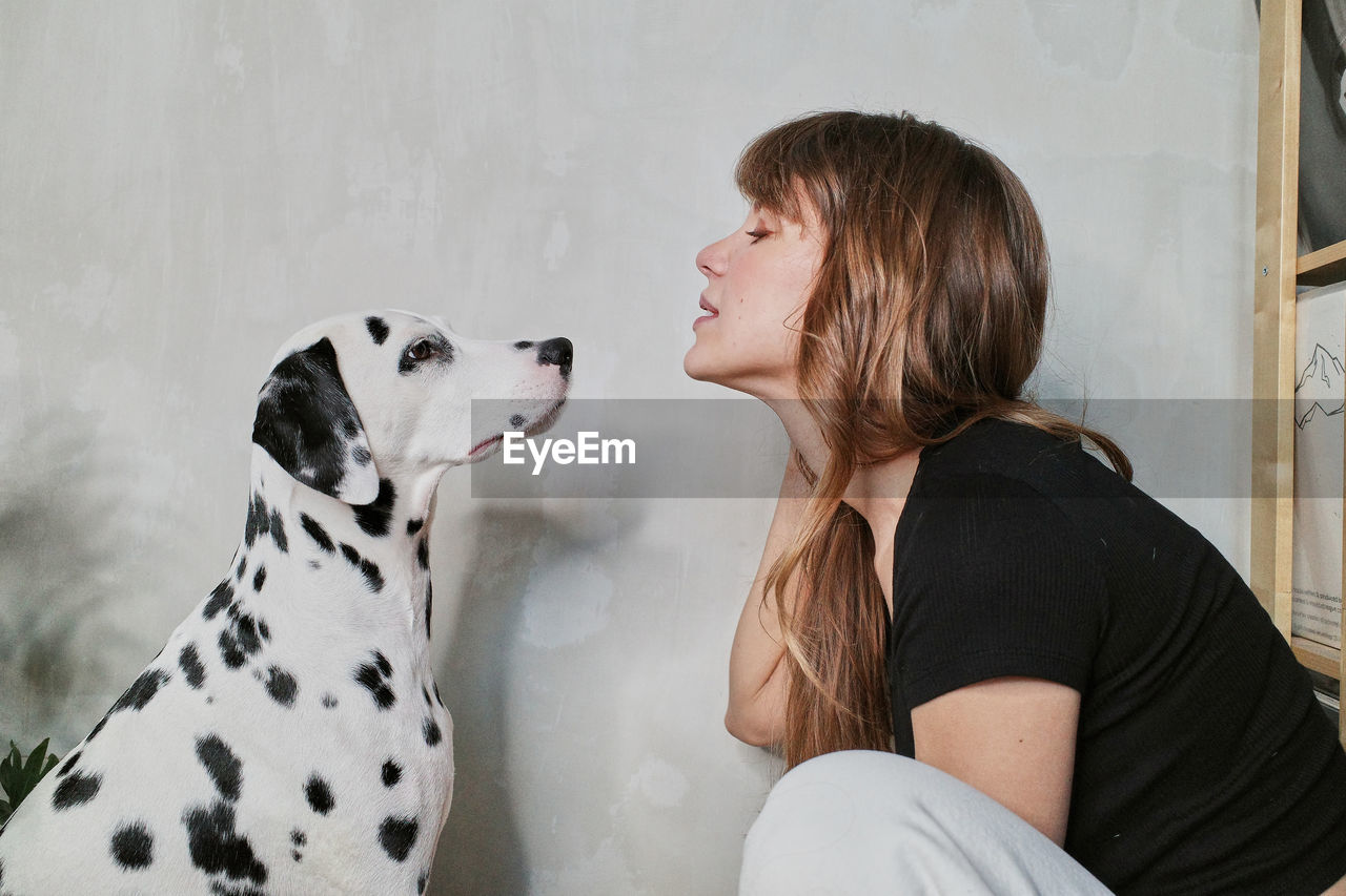 Side view of woman with dog at home