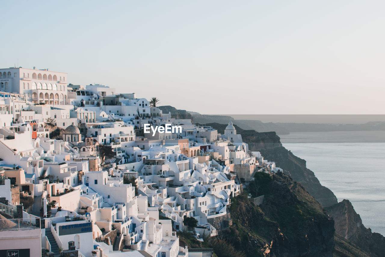 High angle view of townscape by sea against clear sky