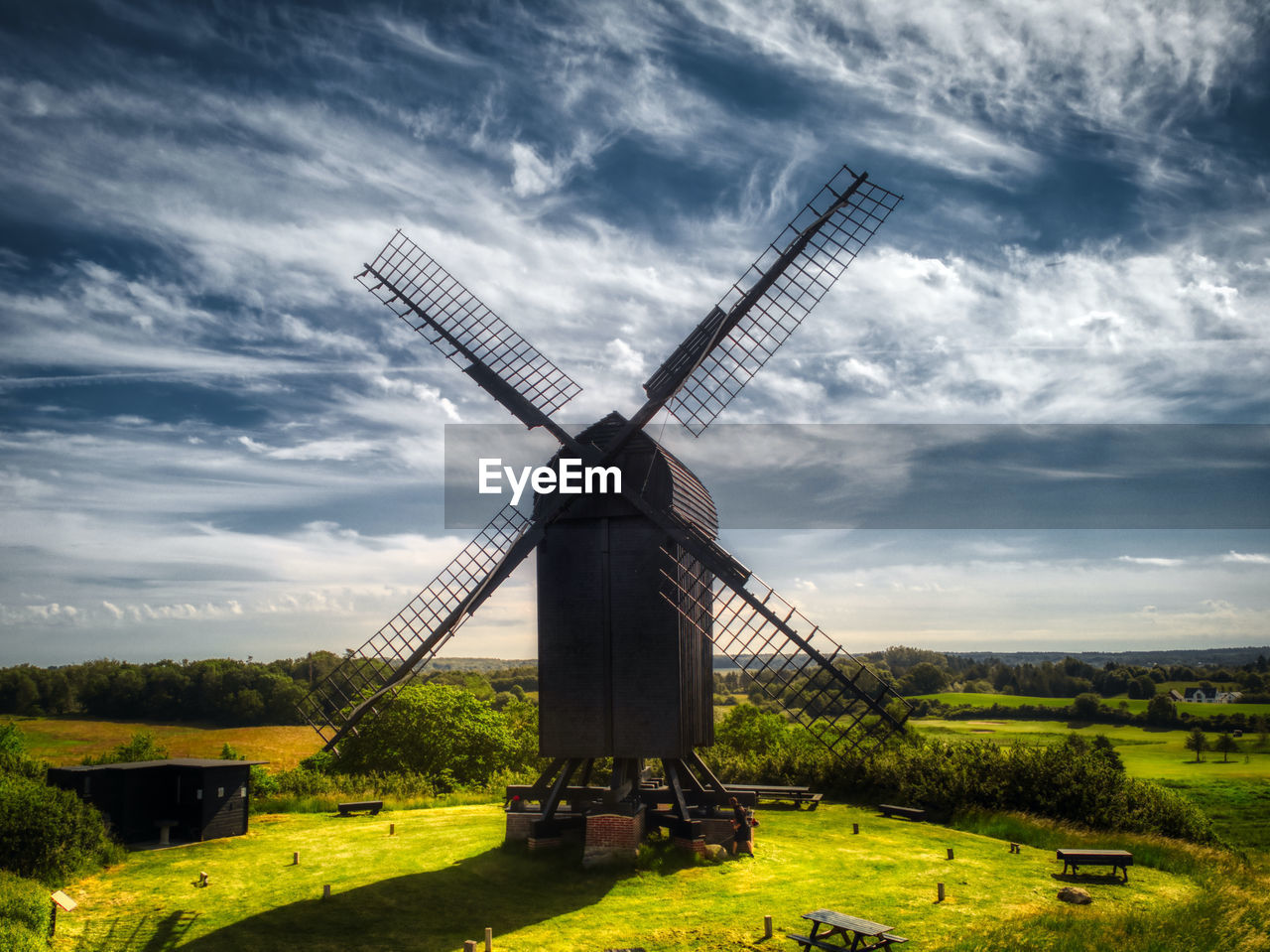 TRADITIONAL WINDMILL ON FIELD AGAINST CLOUDY SKY