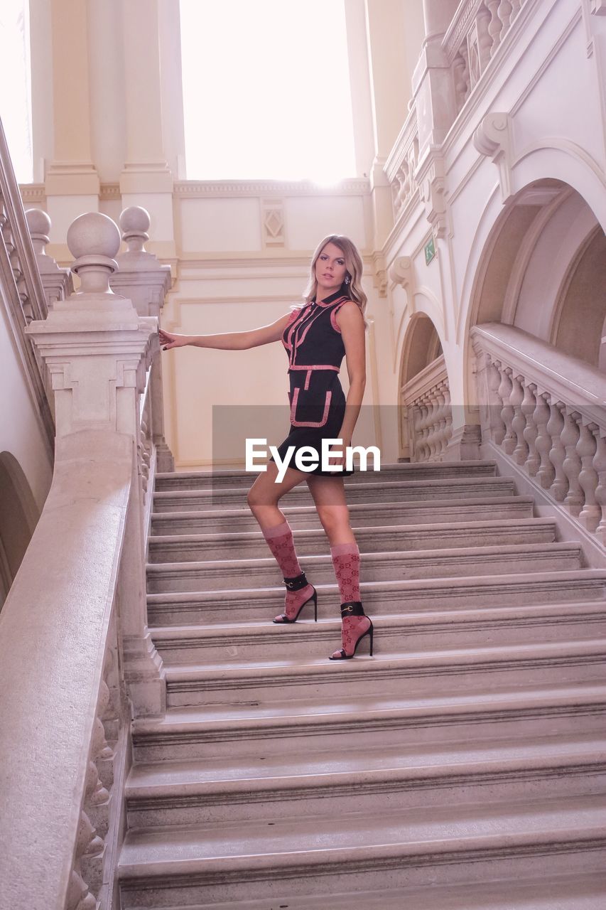 FULL LENGTH PORTRAIT OF WOMAN ON STEPS