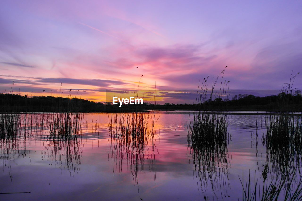 Scenic view of lake against sky at sunset