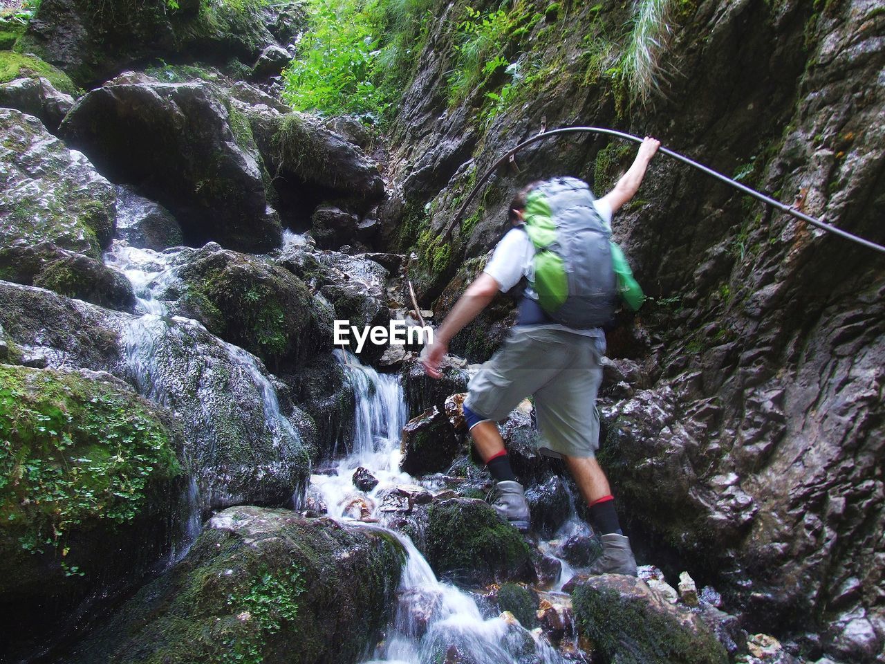 Low angle view of mid adult man climbing on mountain