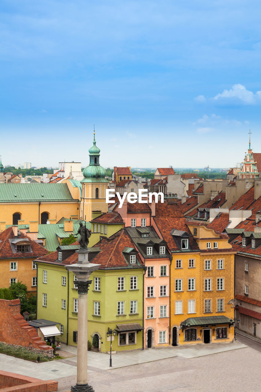 HIGH ANGLE VIEW OF BUILDINGS AGAINST CLOUDY SKY