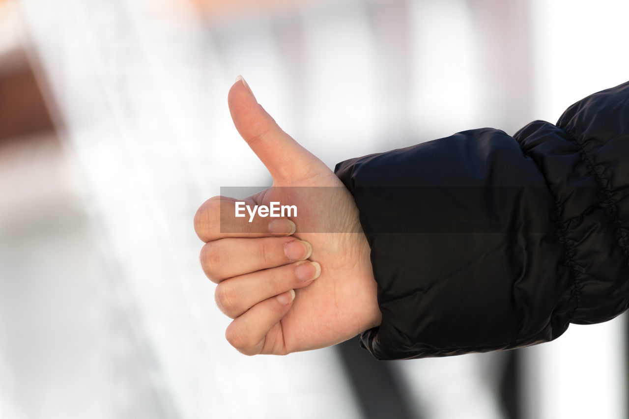 Cropped hand of woman showing thumbs up