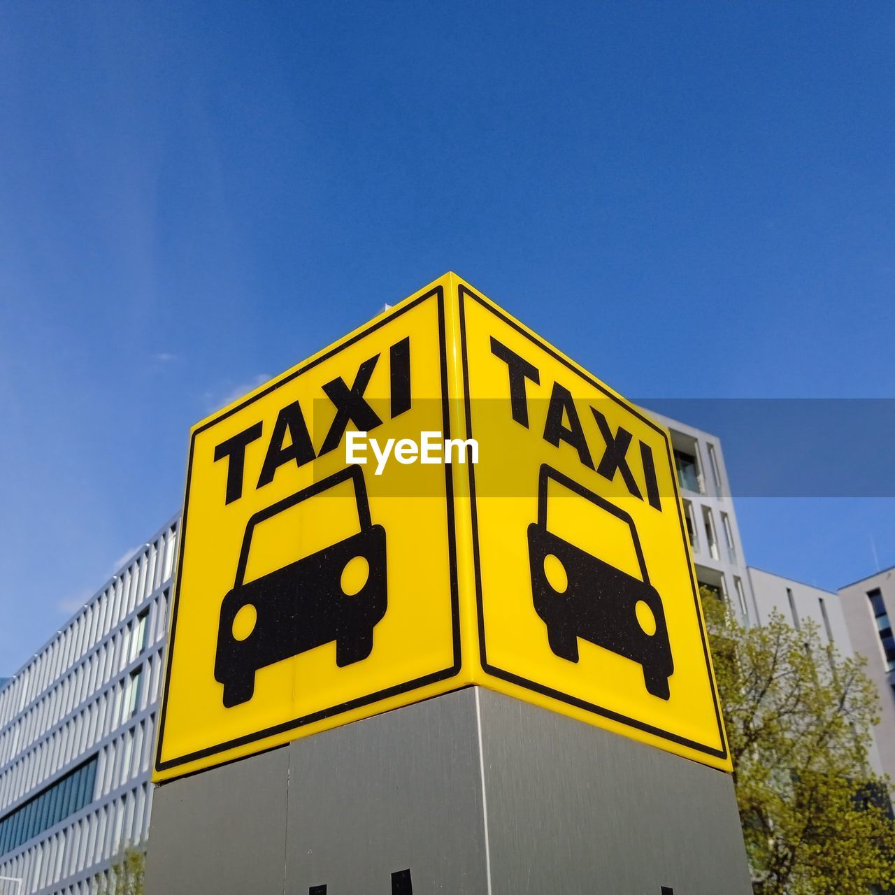 yellow, sign, sky, blue, communication, architecture, clear sky, no people, nature, text, traffic sign, low angle view, transportation, signage, built structure, day, building exterior, outdoors, road, advertising, city, road sign, street sign