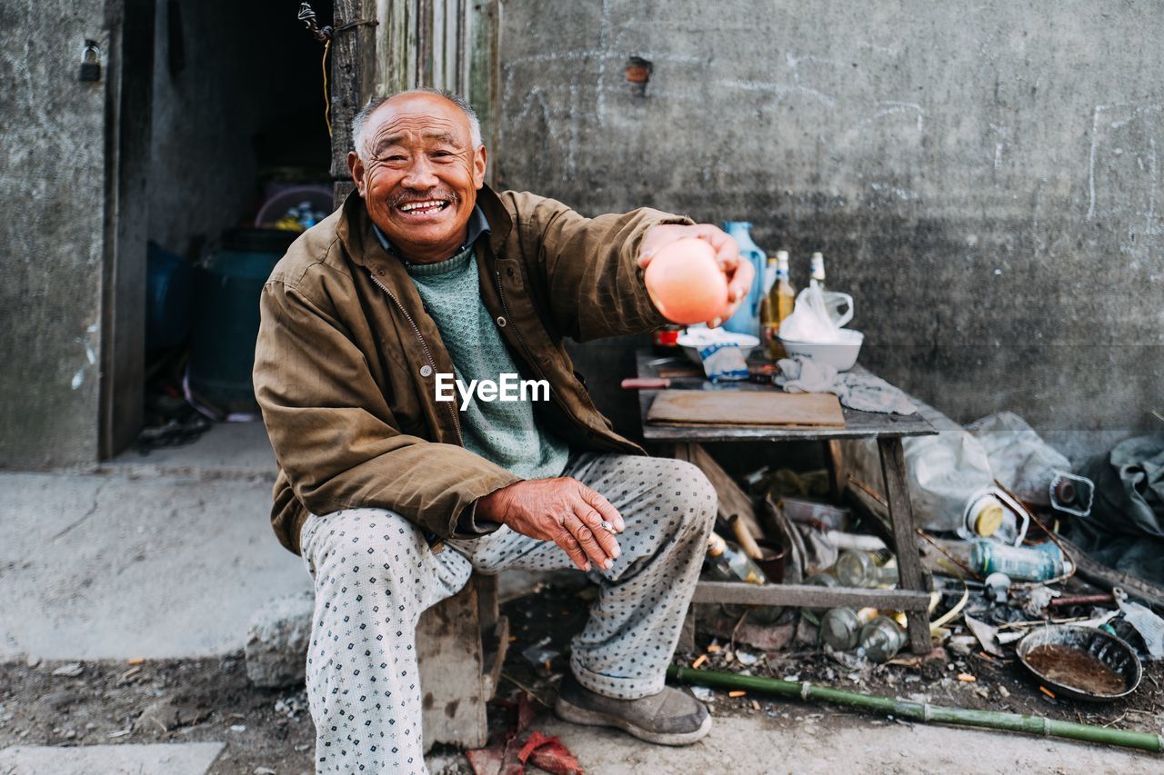 Portrait of a smiling man sitting on road